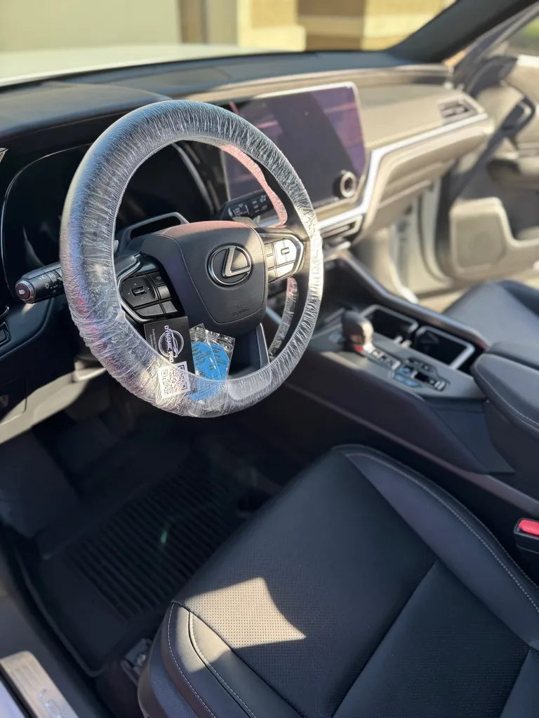 Freshly detailed Lexus interior with a protective steering wheel cover and Dynamic Pro card