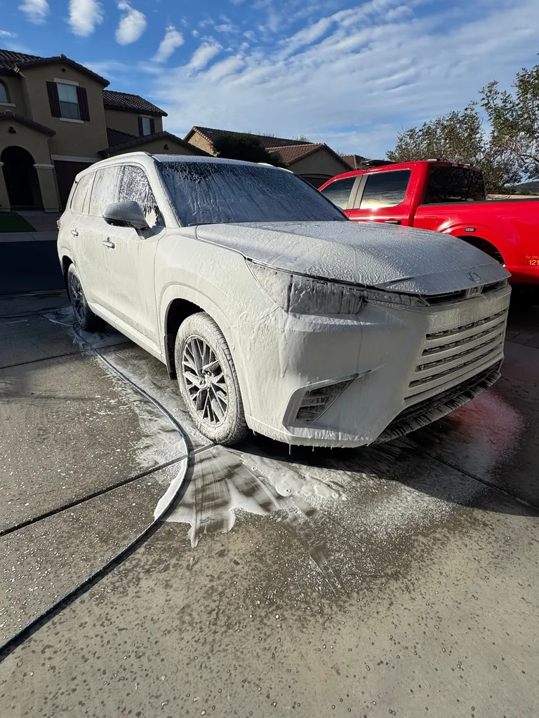 White Lexus SUV covered in foam during a hand wash