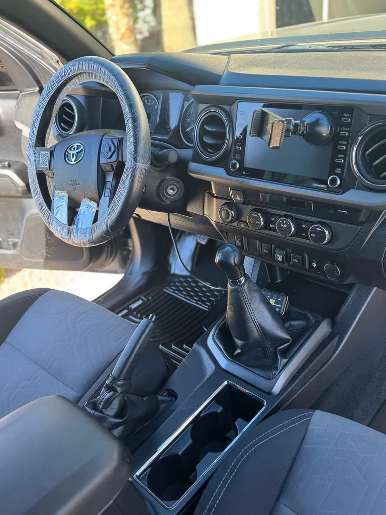 Detailed Toyota Tacoma interior with a protective steering wheel cover