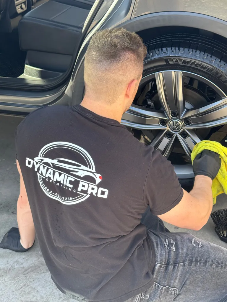 Detailer hand-drying a Volkswagen wheel with a microfiber towel